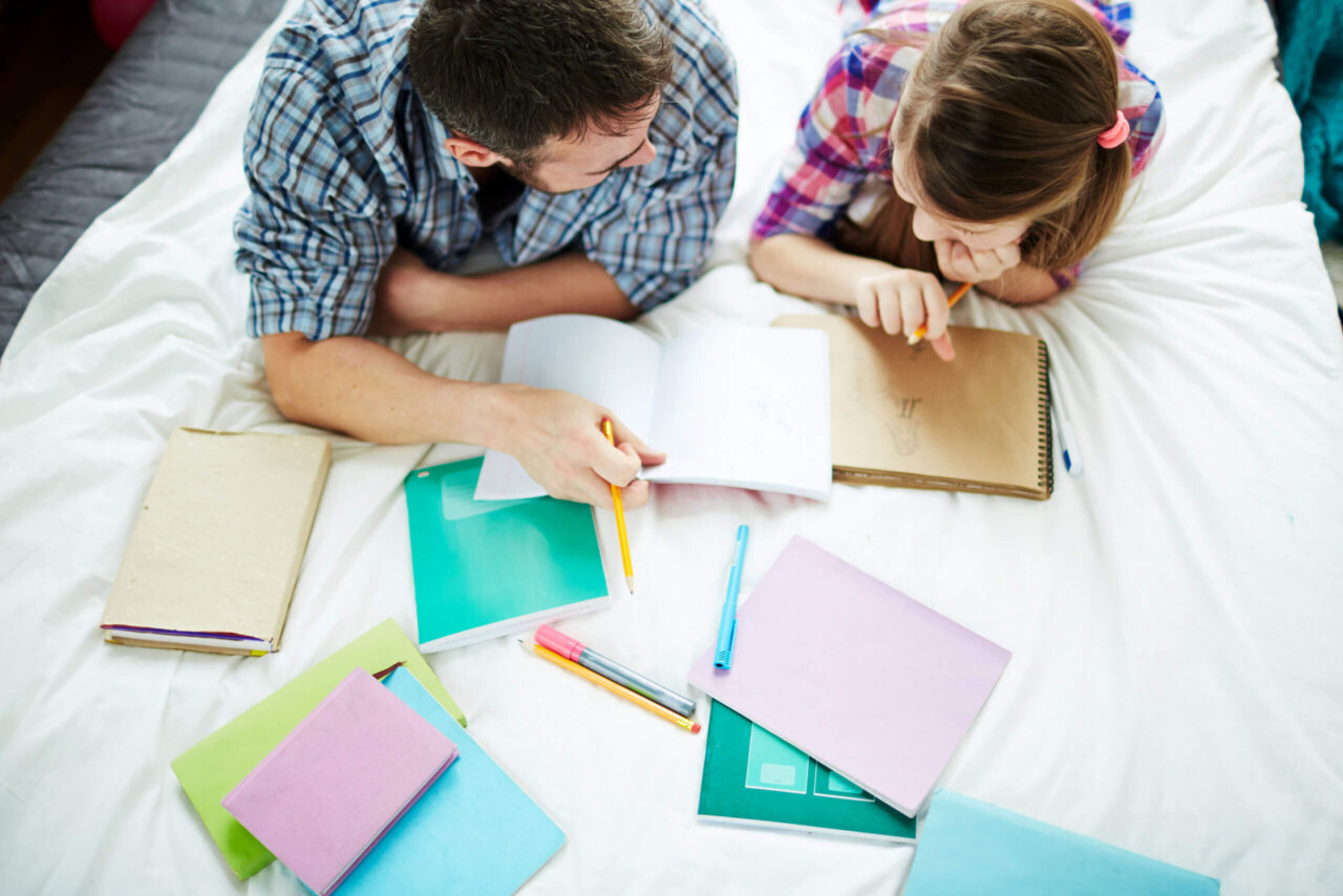 Man helping his teenage daughter to do creative homework