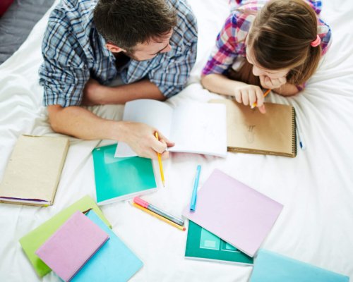 Man helping his teenage daughter to do creative homework
