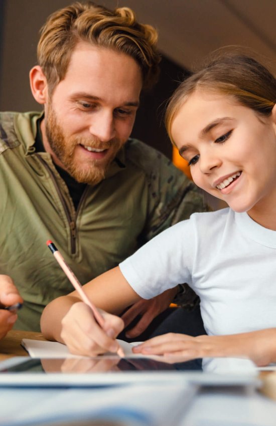 Masculine happy military man doing homework with her daughter at home